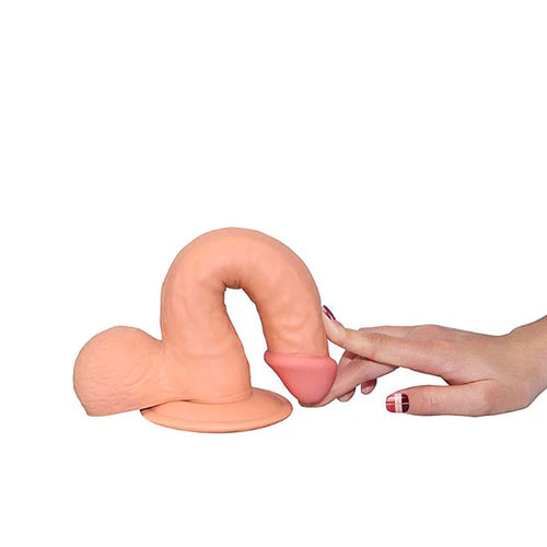 Imagen demostrativa de la flexibilidad del Dildo Realista The Ultra Soft Dude de 20 cm en color piel, con una mano presionando su textura ultra suave y mostrando su capacidad de doblarse.